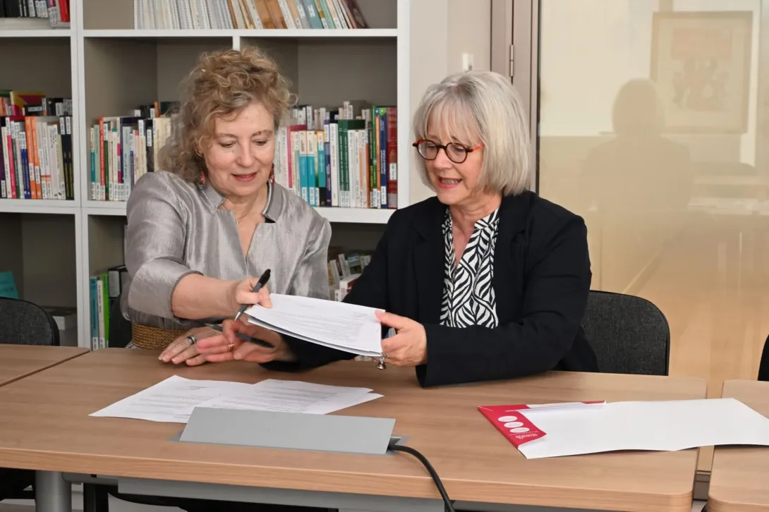deux femmes s'échangent des documents